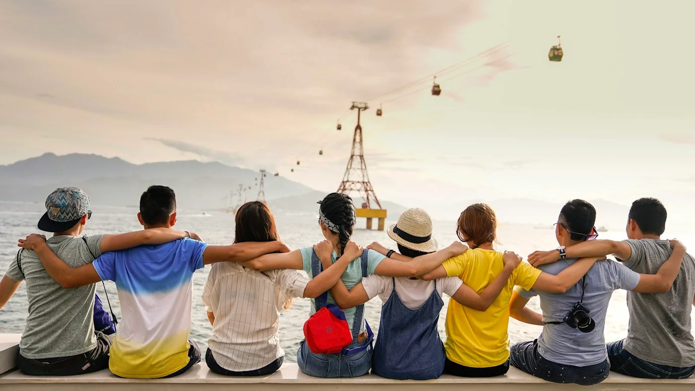 Friends sitting together and looking over a coastal landscape